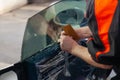 The wizard for installing additional equipment sticks a tint film on the side front glass of the car and flattens it by hand to