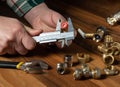 The wizard measures size of fitting using a caliper before connecting water or gas pipe. Close-up of the hands of the master