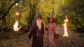 Wizard and sorceress in the autumn forest. Elderly man and woman in carnival costumes for halloween