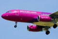 Wizz Air plane flying up in the blue sky, closeup view Royalty Free Stock Photo