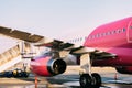 Wizzair plane on a takeoff strip at the airport. Close-up of an airplane wing and engine outside.