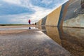 Beautiful water pier in Wladyslawowo with wall full of paintings reflected in puddle at