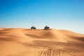 Wo buggy quad bikes riding at bright Al Awir desert landscape