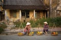 Wo fruit vendors in traditional straw hats