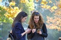 Two girls look at the smart phone with interest in a park in Sofia