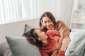 Wo young women spend time next to each other, lying on the bed and laughing