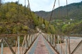 Wobbly old bridge over a mountain river for cars Royalty Free Stock Photo