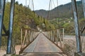 Wobbly old bridge over a mountain river for cars Royalty Free Stock Photo
