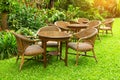 Wodd table and chairs standing on a lawn in garden. Royalty Free Stock Photo