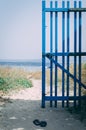 Woden blue gate open towards the beach