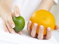 Woiman`s Hands with French Manicure on Nails Holding a Fresh Summer Orange and Limet Fruits Royalty Free Stock Photo