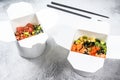 Wok noodle in paper box with vegetables , salmon and tuna. street food to go, take away. White background. Top view