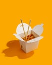 Wok noodles in paper box fast food yellow background Royalty Free Stock Photo