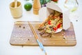 Wok. Noodles with vegetables and beef in take-out box on wooden table Royalty Free Stock Photo