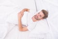 Woke up in good mood. man lye in bed. early morning wake up. man rest white bedroom. cosy weekend at home. time to relax Royalty Free Stock Photo