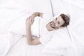 woke up in good mood. man lye in bed. early morning wake up. man rest white bedroom. cosy weekend at home. time to relax Royalty Free Stock Photo