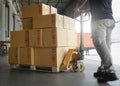 Woker working with hand pallet truck. worker unloading cardboard boxes stack on pallet rack. Shipment boxes. Cargo warehousing. Royalty Free Stock Photo