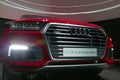 WOLFSBURG, GERMANY - March 22, 2019: Audi Q7 e-tron quattro closeup frontside with lights on and logo in showroom `Autostadt Royalty Free Stock Photo