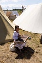 WOLIN, POLAND - AUGUST 6, 2022: XXVII Festival of Slavs and Vikings, Medieval woman reenactor playing a psaltery