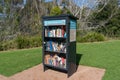 Outdoor library bookcase with books in Wollongong Botanic Garden on sunny day