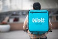 WOLT logo on a blue box by a courier on a bicycle - international food delivery service