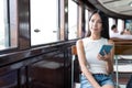 Woma holding smart phone inside ferry