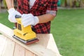 Woman Carpenter working with wood electrical sanding machine Royalty Free Stock Photo