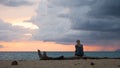 A womam is Sitting on a beach in Puerto Rico, watching the sunset and the arrival of a storm over the Caribbean Sea. Rincon, Royalty Free Stock Photo