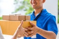 Woman accepting a delivery of cardboard boxes from deliveryman Royalty Free Stock Photo