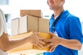 Woman accepting a delivery of cardboard boxes from deliveryman Royalty Free Stock Photo