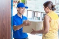 Woman accepting a delivery of cardboard boxes from deliveryman Royalty Free Stock Photo