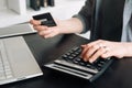 Woman accountant in office, using calculator and holding credit card. Close-up of hands. Online shopping and finance Royalty Free Stock Photo