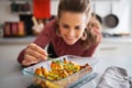 Woman adding rosmarinus to baked pumpkin. Closeup