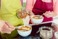 Woman adding toppings to oatmeal breakfast Royalty Free Stock Photo