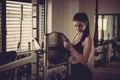 Woman adding weight on a bar as she workout in fitness gym