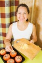 Woman adds cheese to stuffed tomato