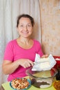 Woman adds margarine into dish