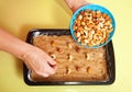 Woman adds nuts into dough