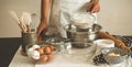 Woman adds some flour to dough on wooden table. Woman hands kneading fresh dough. Royalty Free Stock Photo