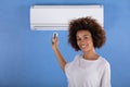 Woman Adjusting Air Conditioner With Remote Control Royalty Free Stock Photo