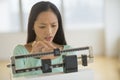 Woman Adjusting Balance Weight Scale At Gym