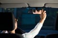 Woman adjusting rear mirror