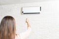 Woman Adjusting Temperature Of Air Conditioner Royalty Free Stock Photo