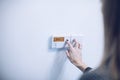 Woman adjusting temperature on home heating control Royalty Free Stock Photo