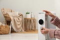 Woman adjusting temperature on modern portable electric heater indoors, closeup. Space for text Royalty Free Stock Photo