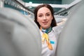 Woman administrator of dry-cleaning office standing between racks with garment Royalty Free Stock Photo
