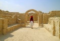 Woman Admiring the Bahrain Fort or Qal`at al-Bahrain, UNESCO World Heritage Site in Manama, Bahrain Royalty Free Stock Photo