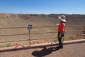 Woman admiring Meteor Crater near Winslow, Arizona.