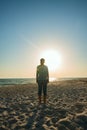 Woman adventurer is standing on the wild seashore