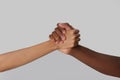 Woman and African American man clasping hands on light grey background, closeup Royalty Free Stock Photo